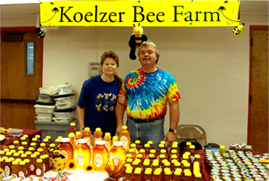 Bill and Teri Koelzer standing at a tradeshow booth with their natural honey products